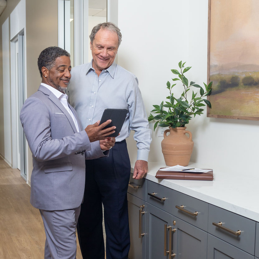 Two people learn about TruStage by looking at a tablet