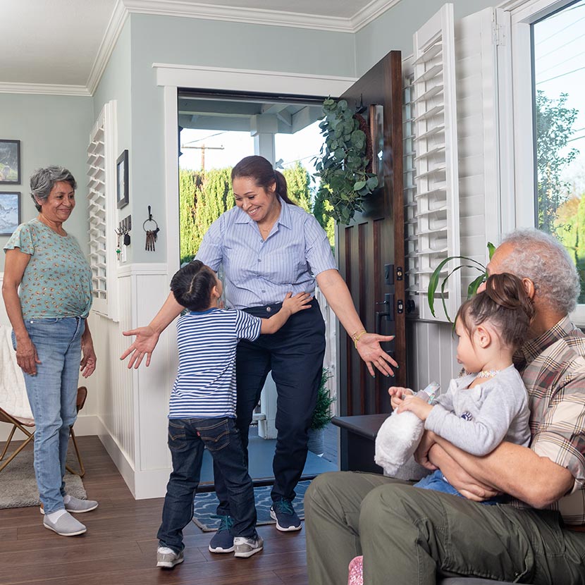 A child and mom hug in front of grandparents that are secure in retirement thanks to ZoneChoice Income Annuity from TruStage™.