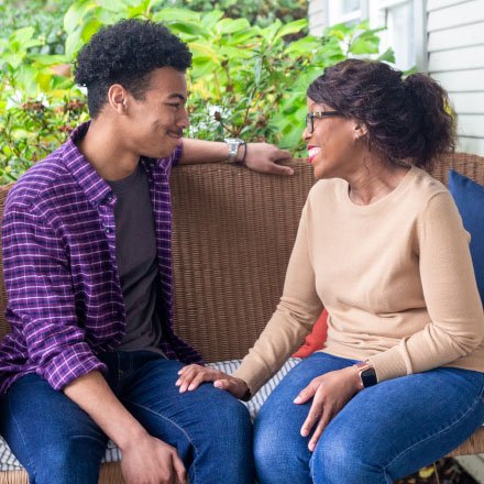 A younger couple on a couch discuss their TruStage Life Insurance policy.