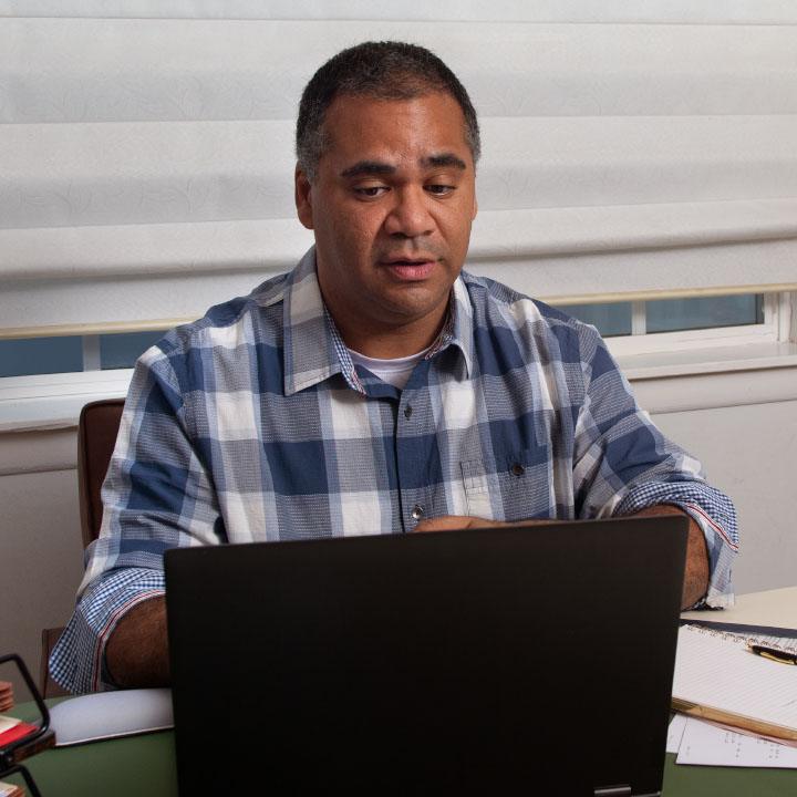 A man reviews his TruStage Insurance application using his laptop.