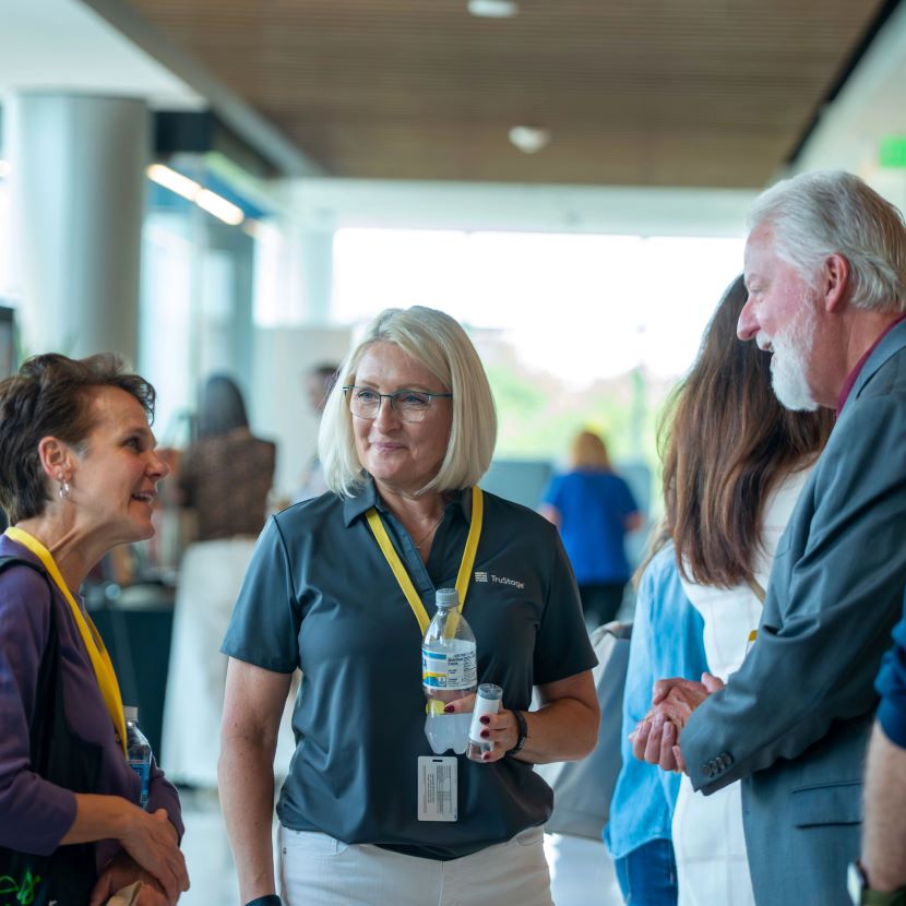 Three employees meet while attending the TruStage 90th Anniversary Celebration.